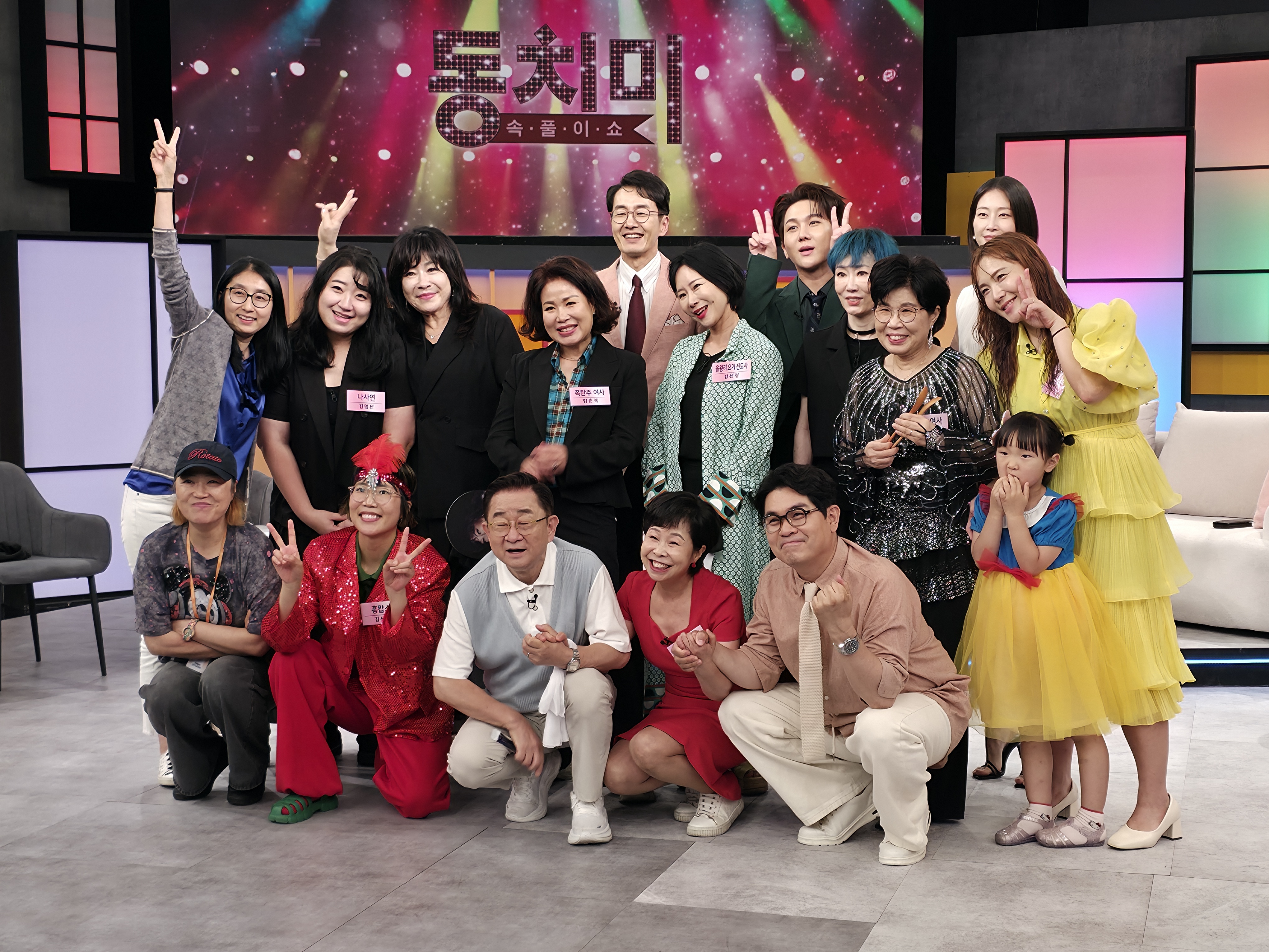 SBS '동치미' 녹화 현장에서 출연진과 스태프들이 기념촬영을 하고 있다. 〈사진 제공〉
alt: '동치미 속풀이쇼' 세트를 배경으로 방청객과 출연진 등 20여 명이 브이 포즈를 취하며 찍은 단체 기념사진