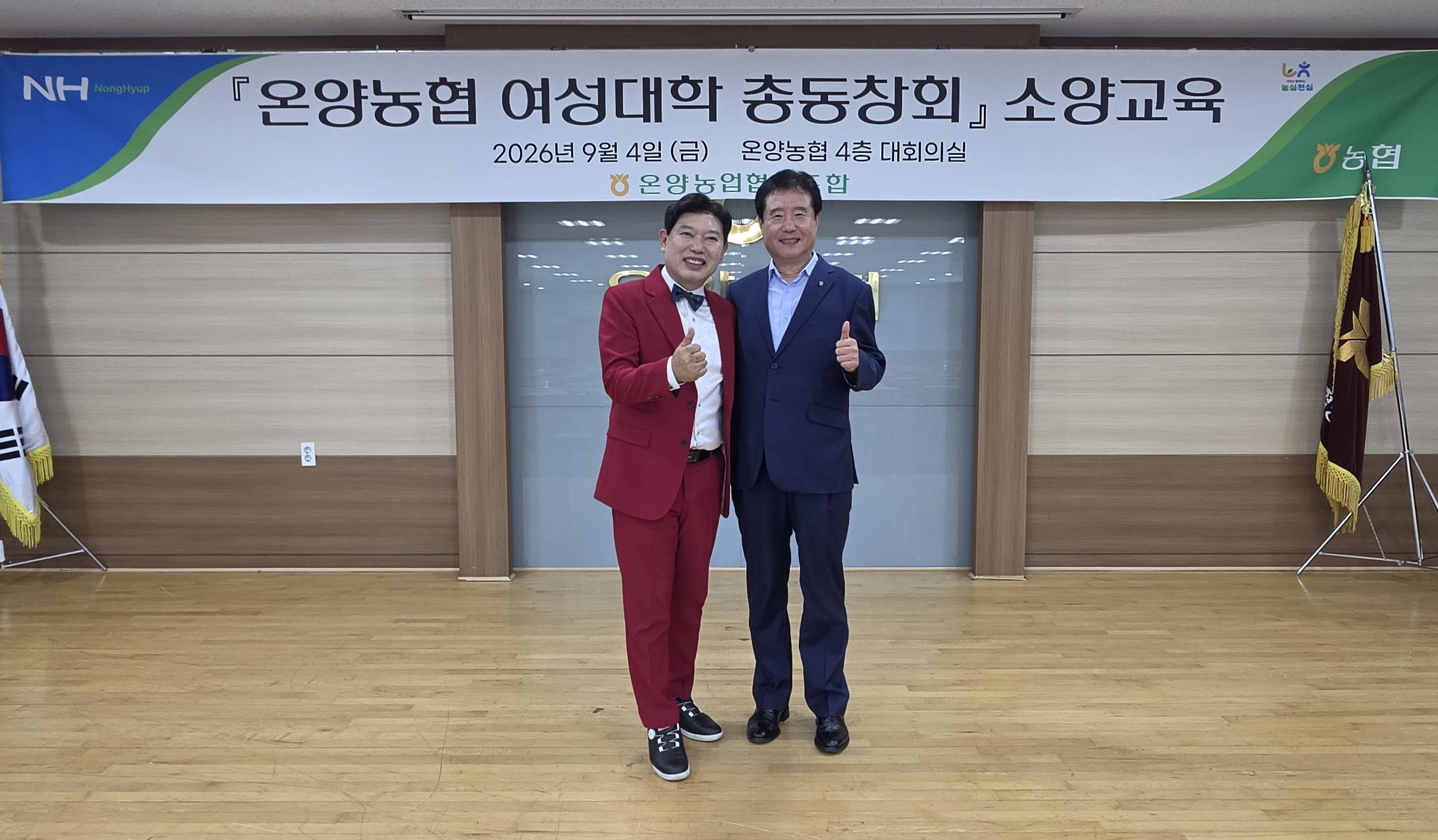 온양농협 여성대학 총동창회 소양교육 현수막 앞에서 백성현 조합장과 붉은 정장 차림의 성창운 총장이 엄지를 들어 보이는 모습