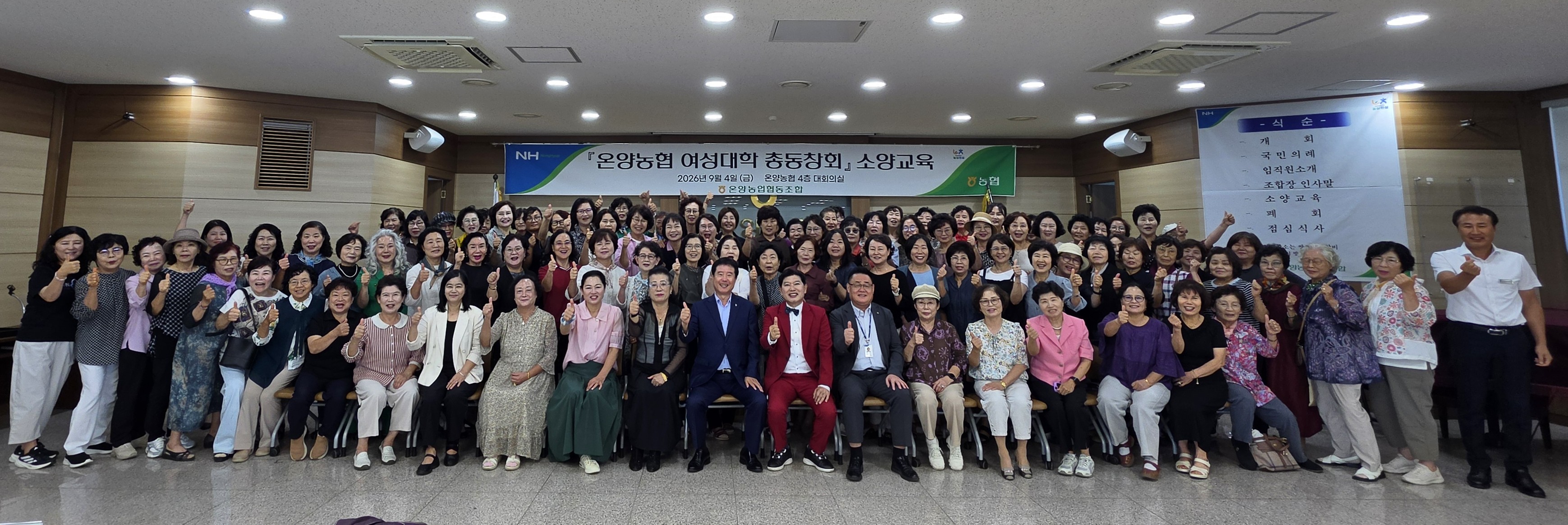 온양농협 4층 대회의실에서 여성대학 총동창회 소양교육 수료생 100여 명이 백성현 조합장과 함께 엄지를 들어 보이는 단체 기념사진